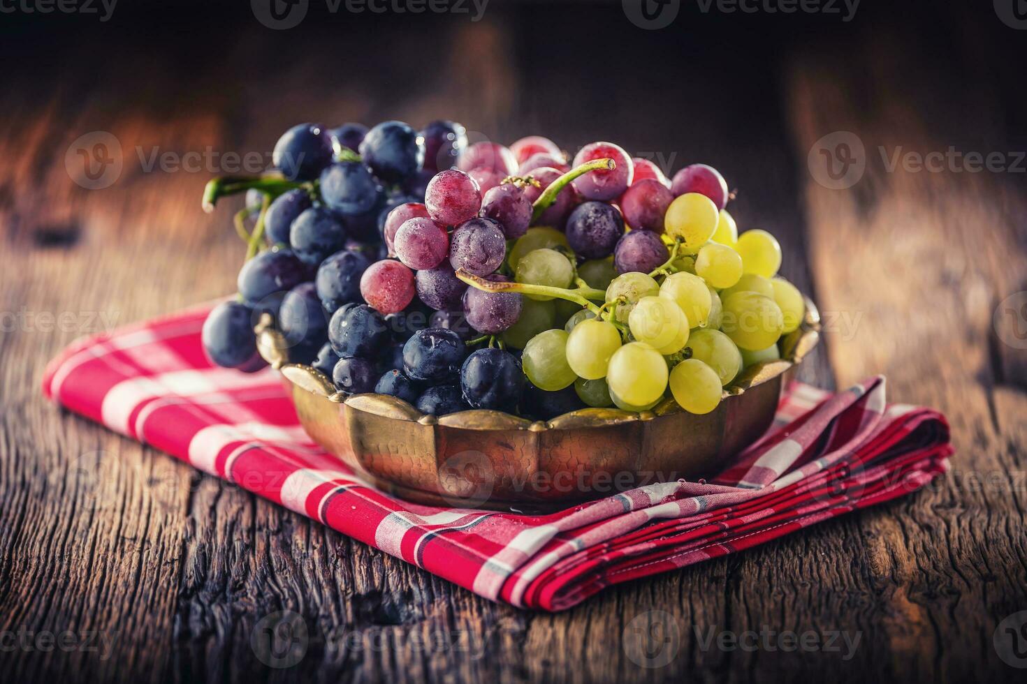 Grape. Bunch of multicolored grapes in retro bowl on old oak table photo