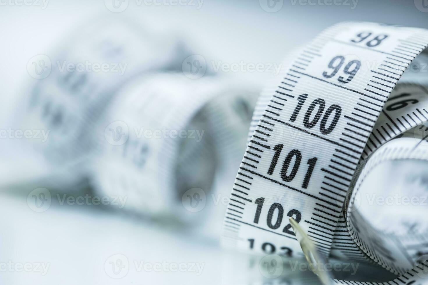 Curved measuring tape. Measuring tape of the tailor. Closeup view of white measuring tape photo