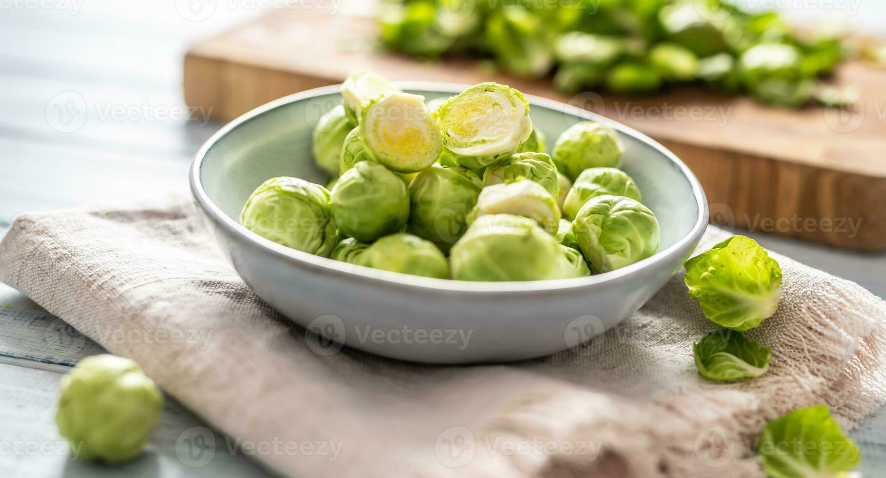 Fresh brusseles sprouts in bowl on kitchen table photo