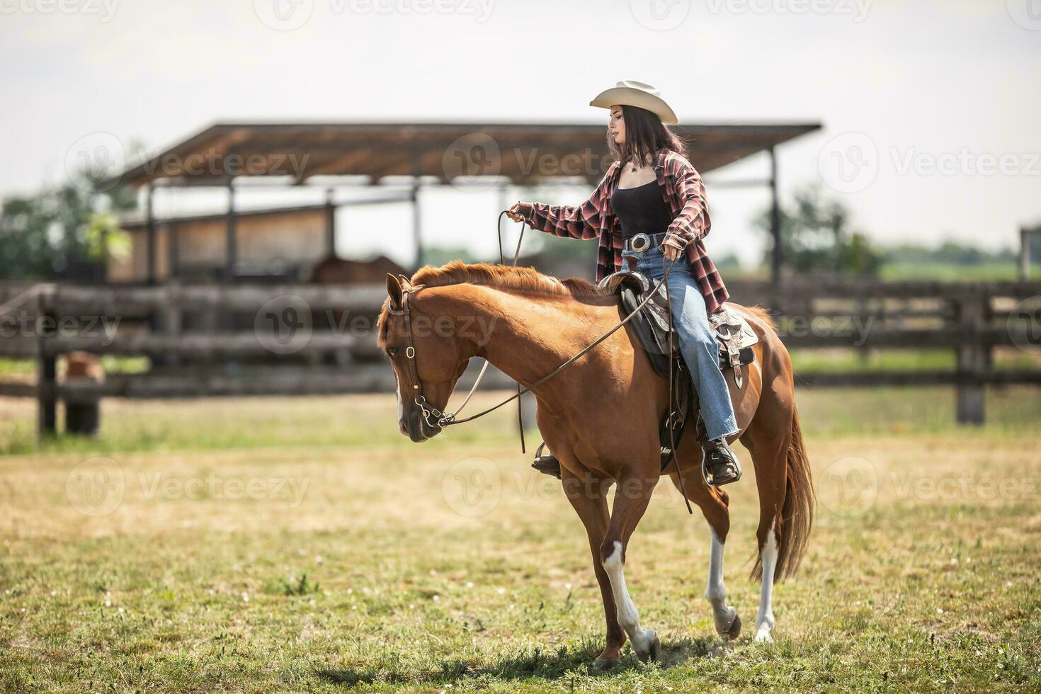 Young cowgirl leads her horse during a ride on a ranch photo