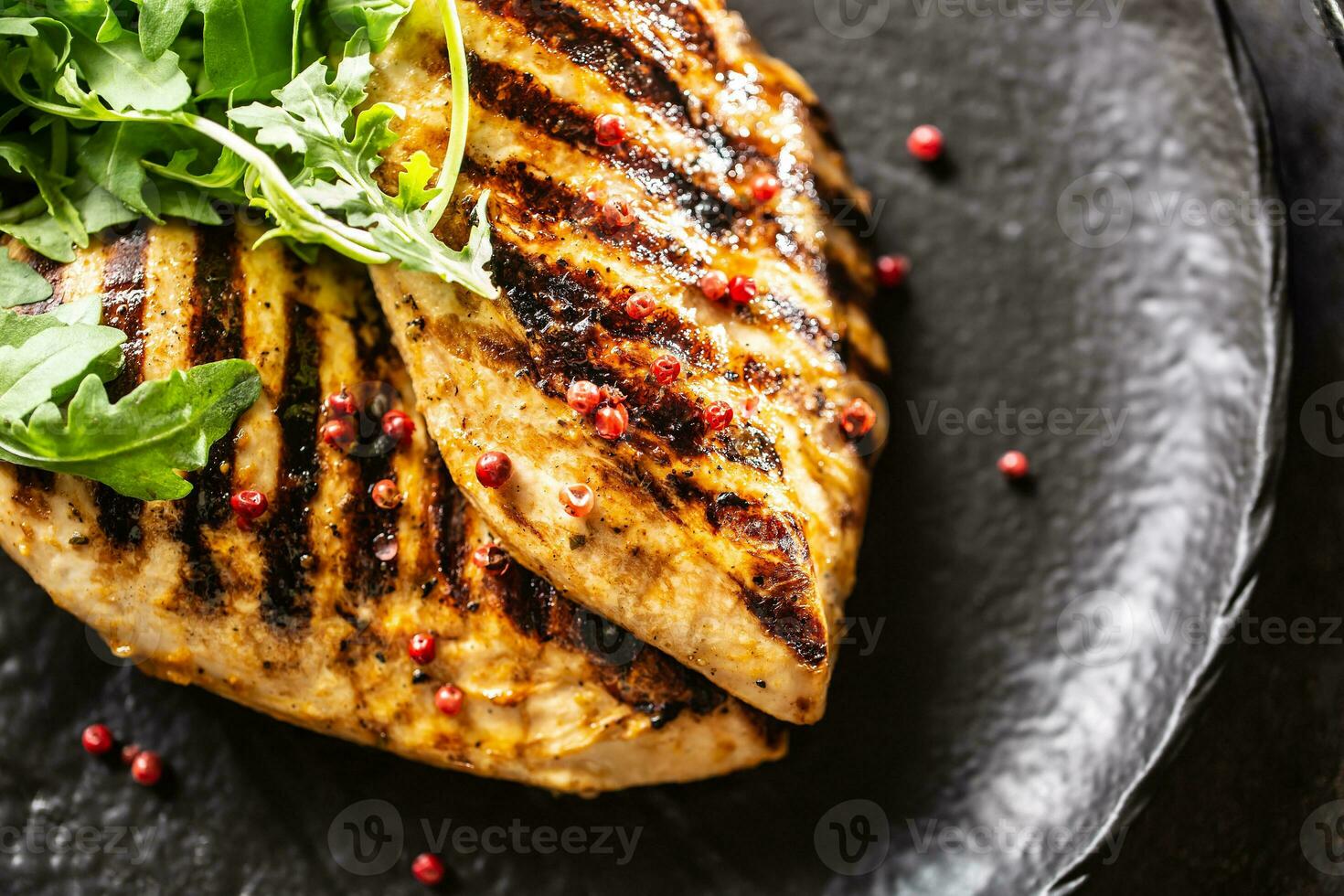 Chicken breast grilled with spices peper salt tomatoes and arugula photo