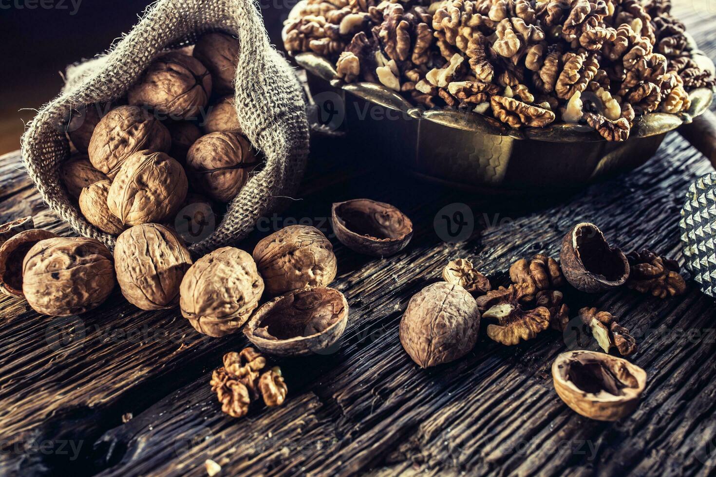 Walnut kernels whole walnuts in burlap sack and vintage bowl photo