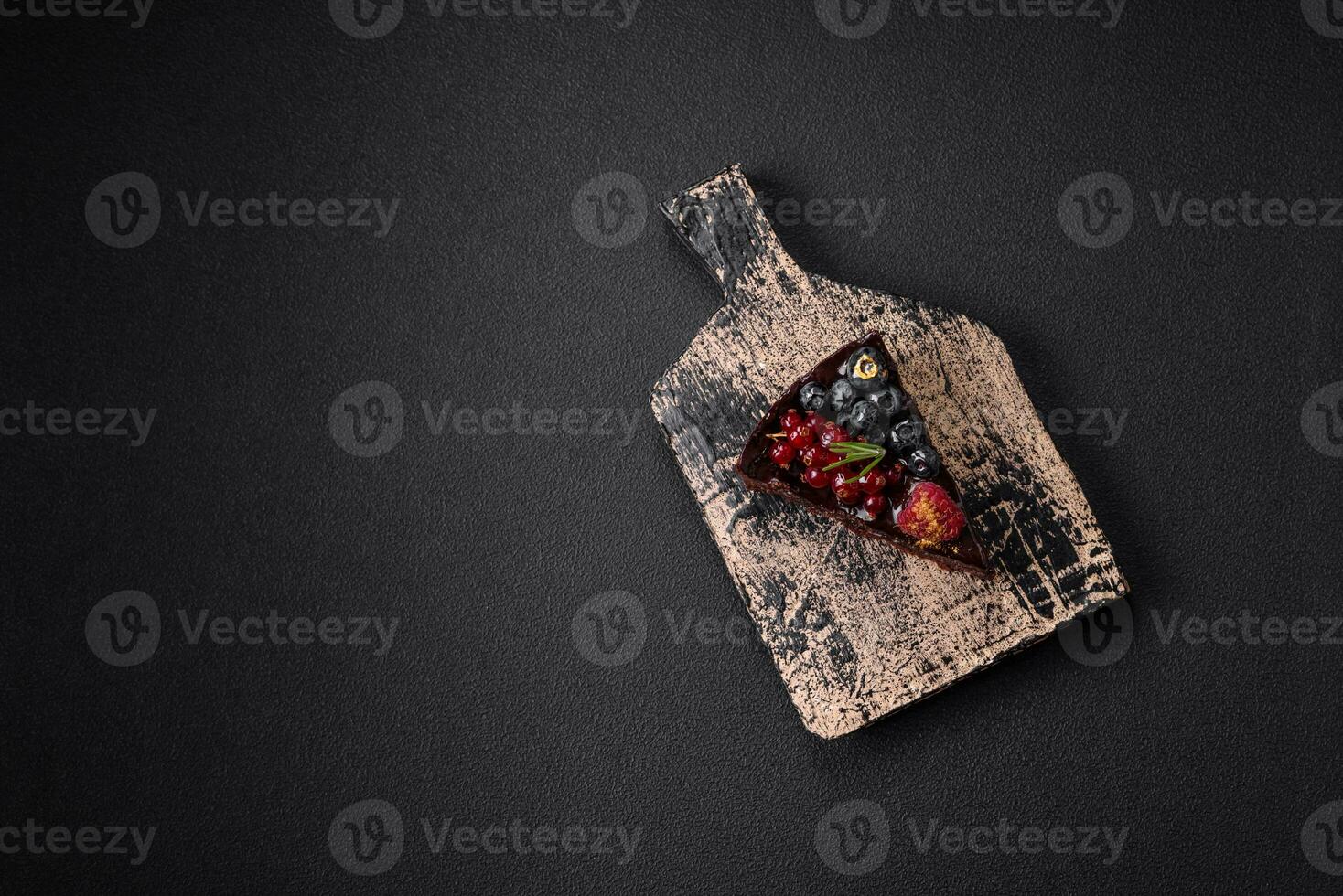 Delicious sweet chocolate brownie cake with blueberries, currants and raspberries photo