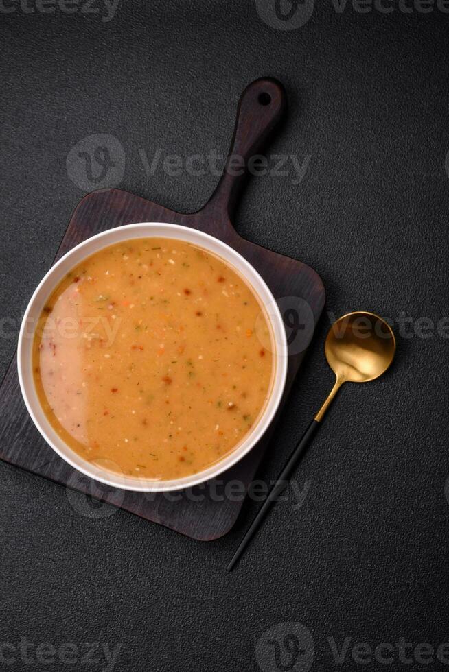 Delicious fresh vegetable soup with carrots, peppers, potatoes and onions photo