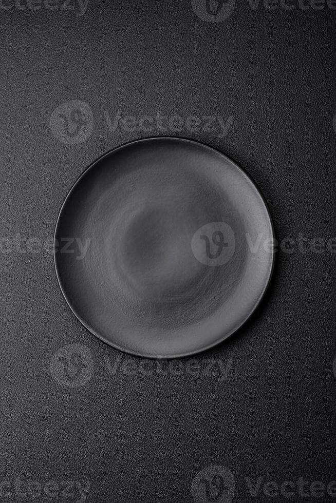 Empty black plate over dark stone background with copy space photo