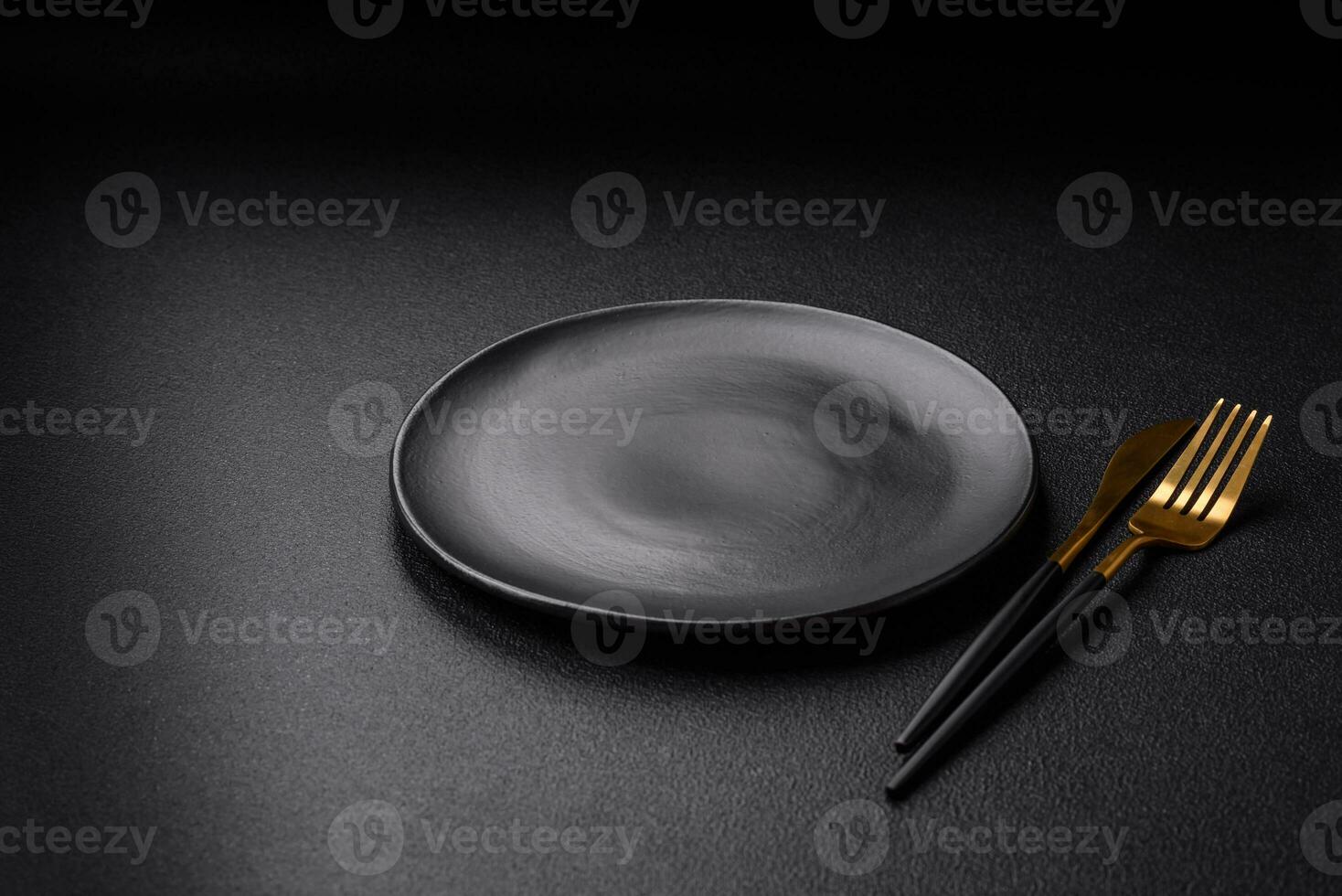 Empty black plate over dark stone background with copy space photo