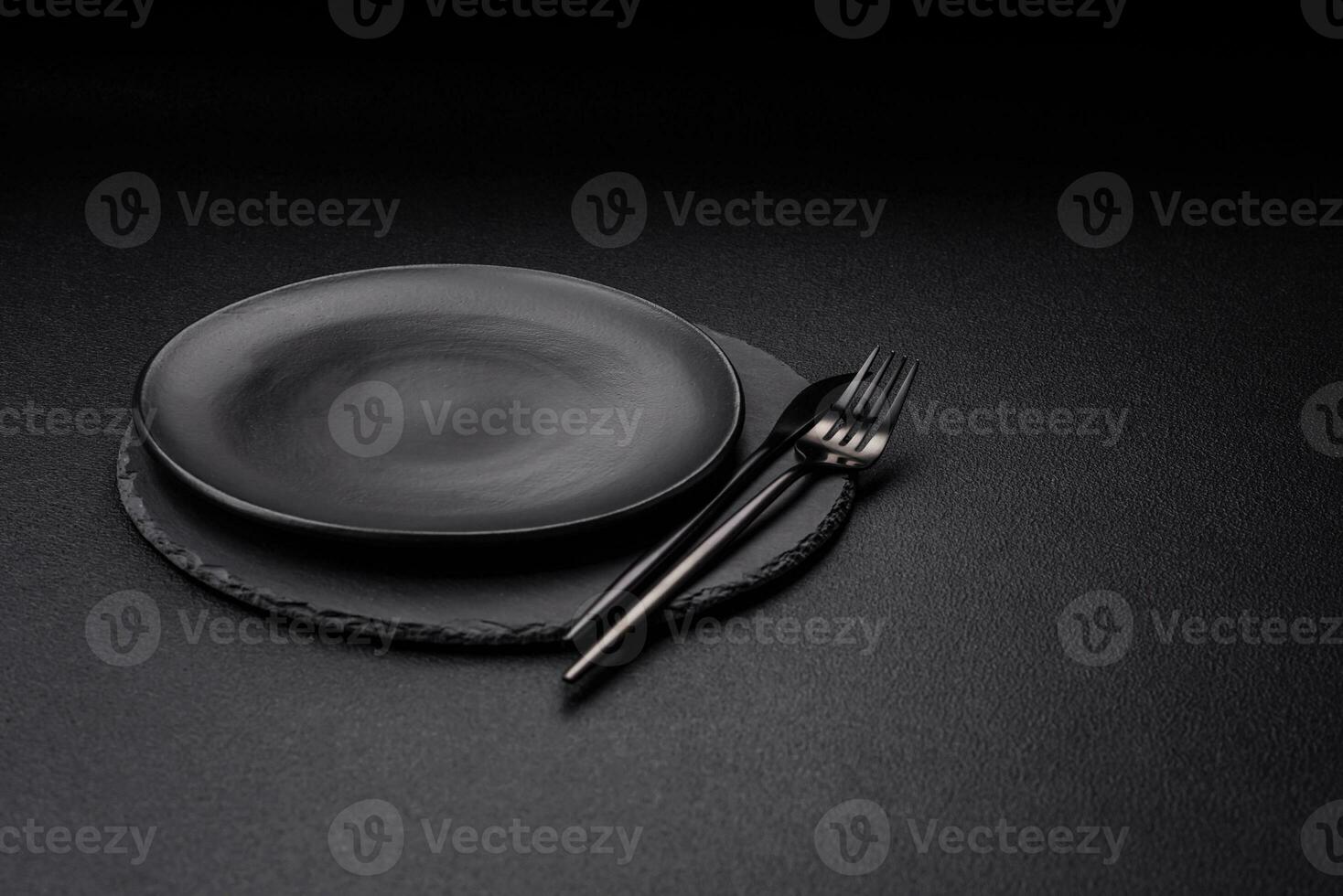 Empty black plate over dark stone background with copy space photo