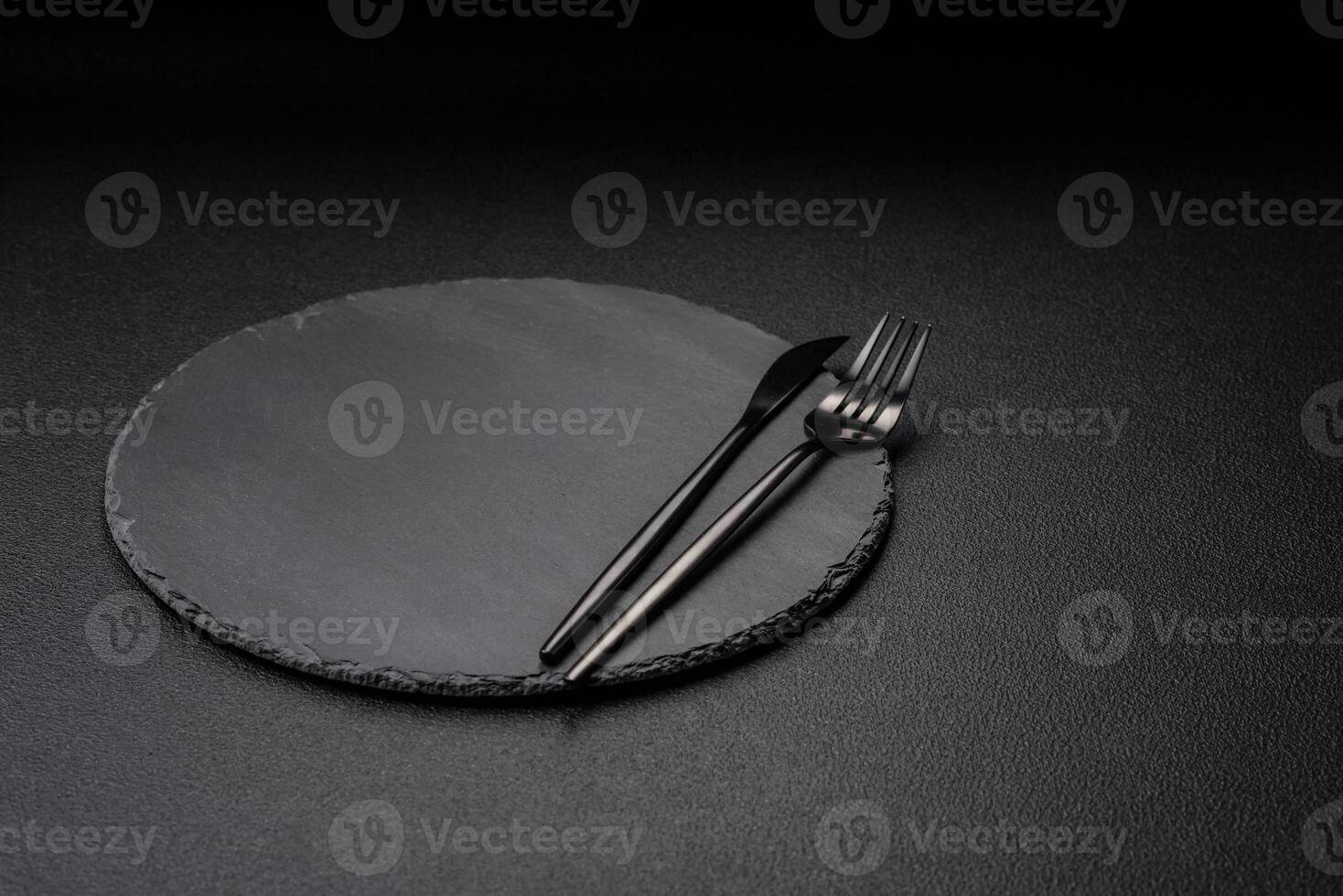 Empty black plate over dark stone background with copy space photo