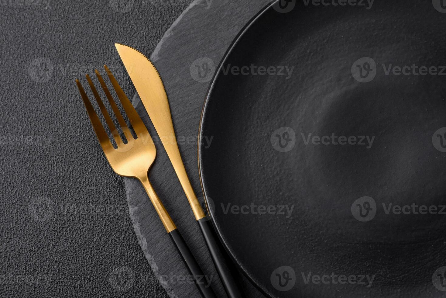 Empty black plate over dark stone background with copy space photo