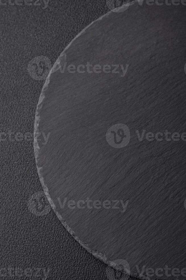 Empty black plate over dark stone background with copy space photo