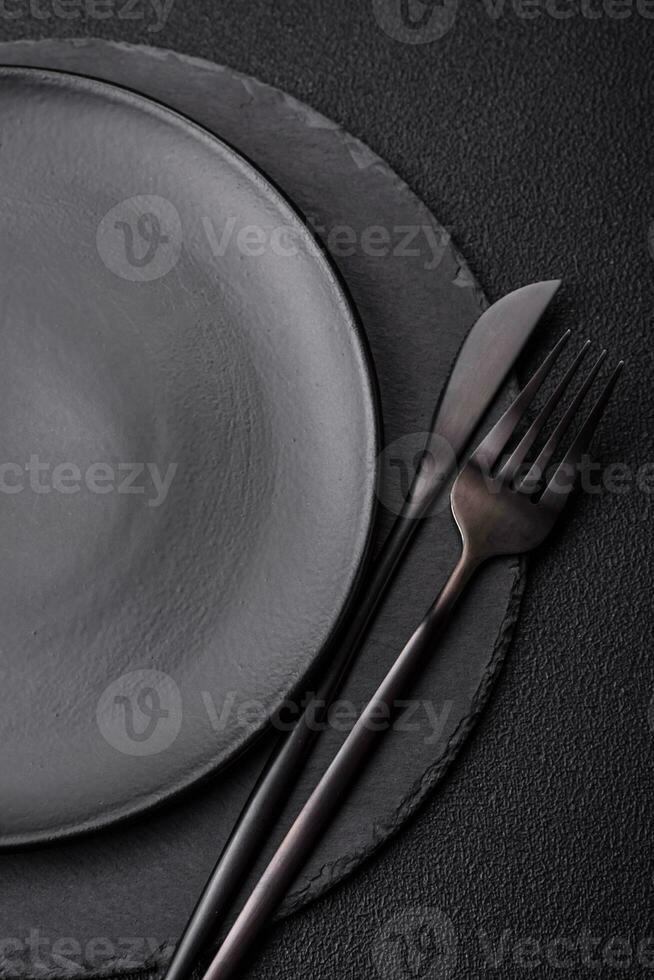 Empty black plate over dark stone background with copy space photo
