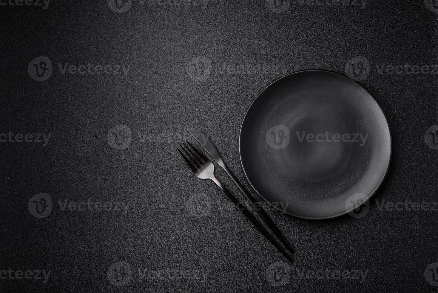 Empty black plate over dark stone background with copy space photo
