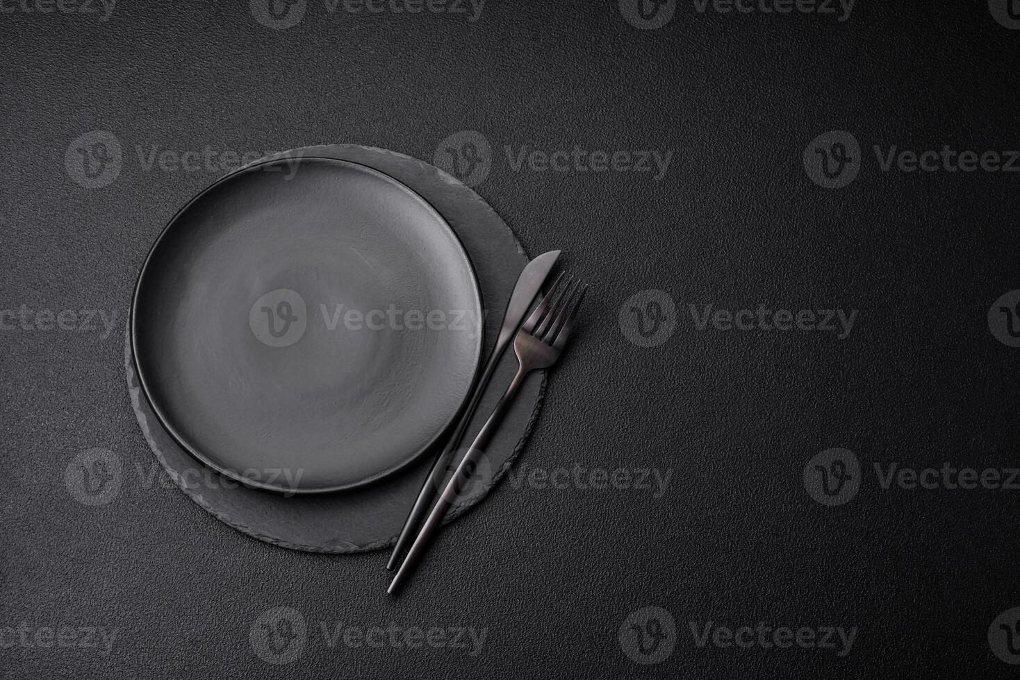 Empty black plate over dark stone background with copy space photo