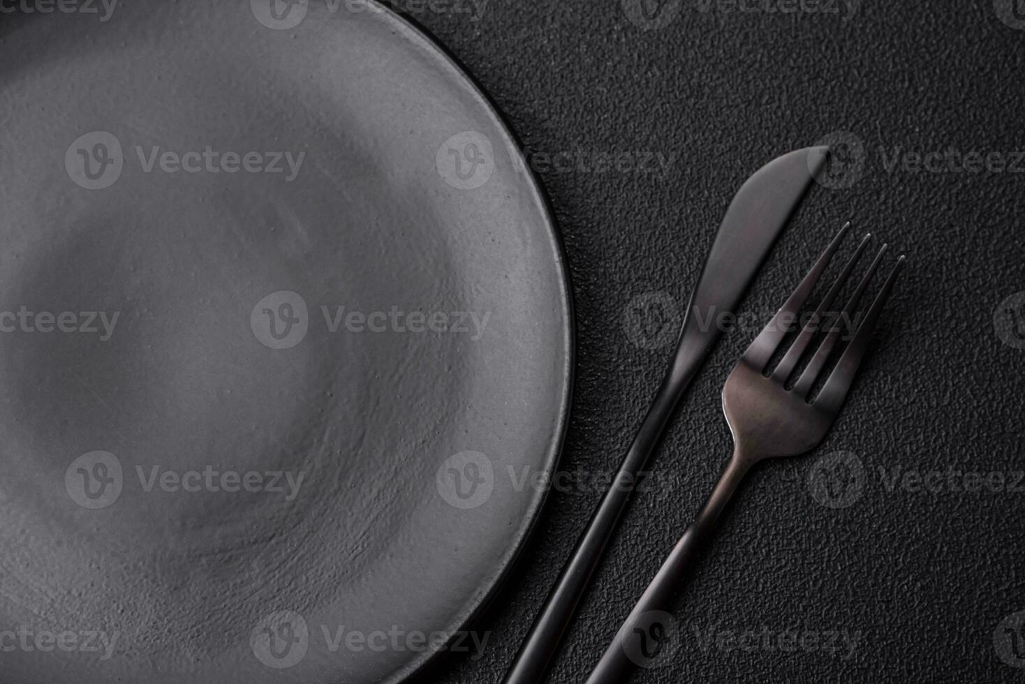 Empty black plate over dark stone background with copy space photo