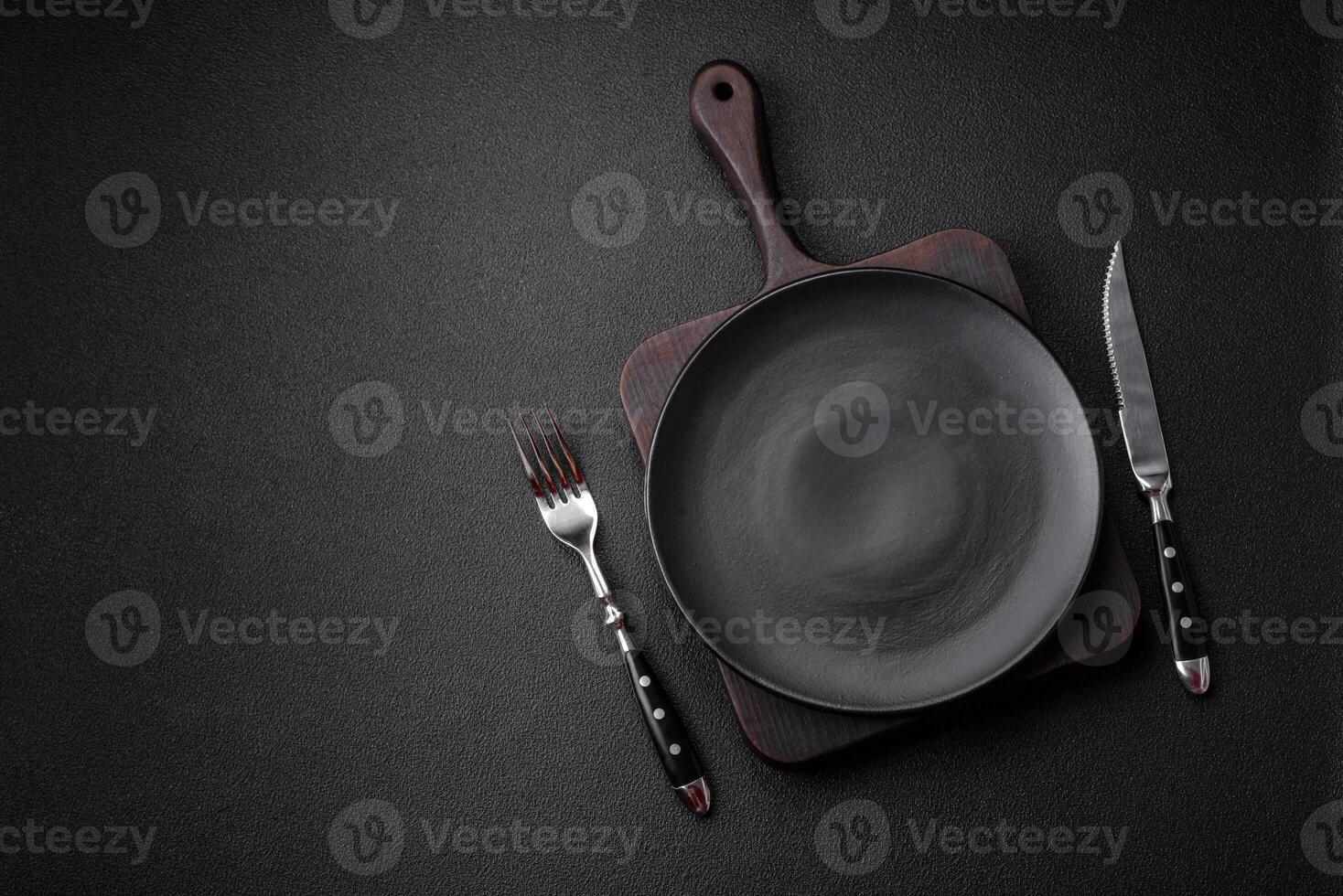 Empty black plate over dark stone background with copy space photo