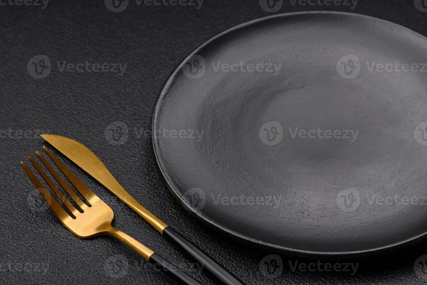 Empty black plate over dark stone background with copy space photo