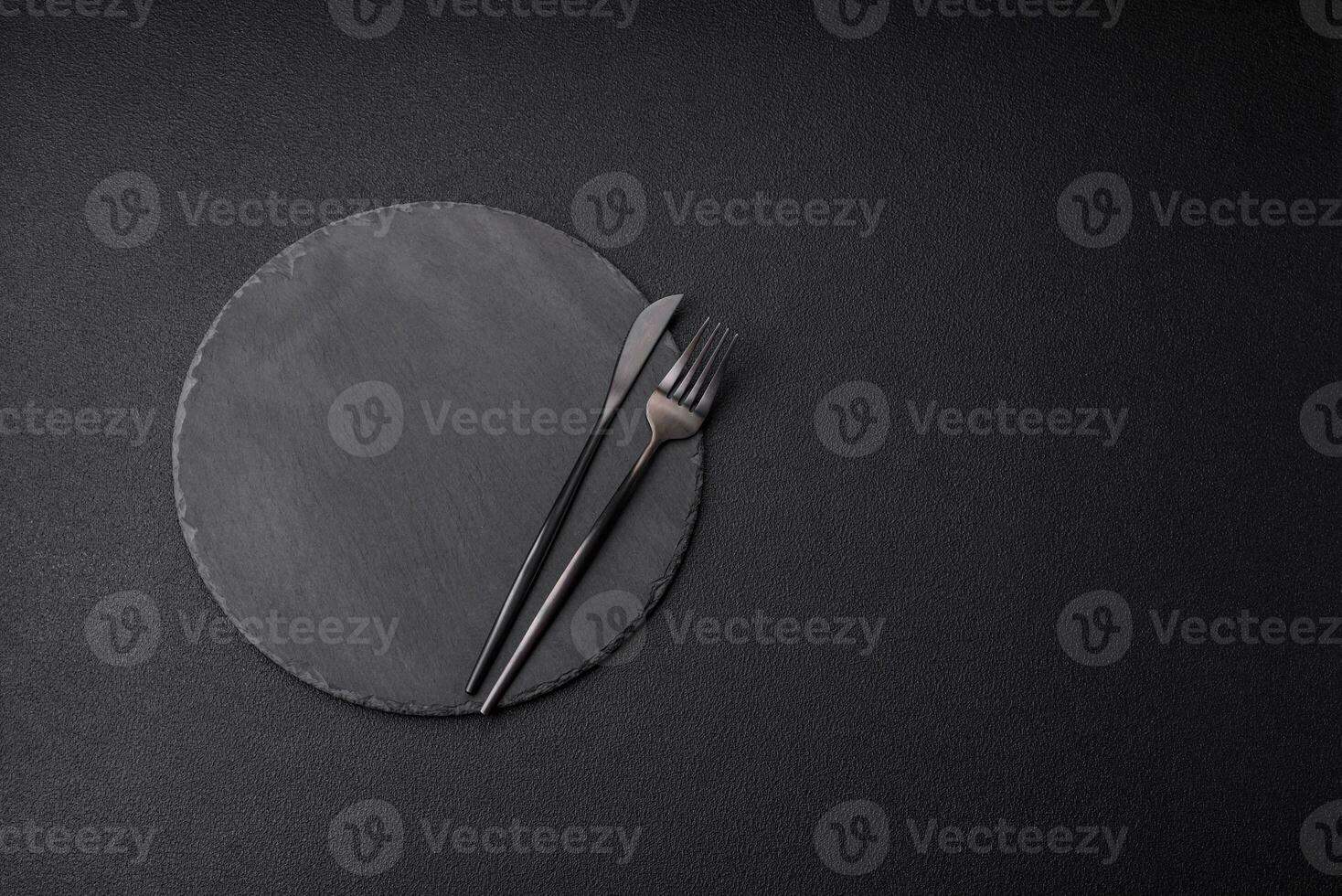 Empty black plate over dark stone background with copy space photo