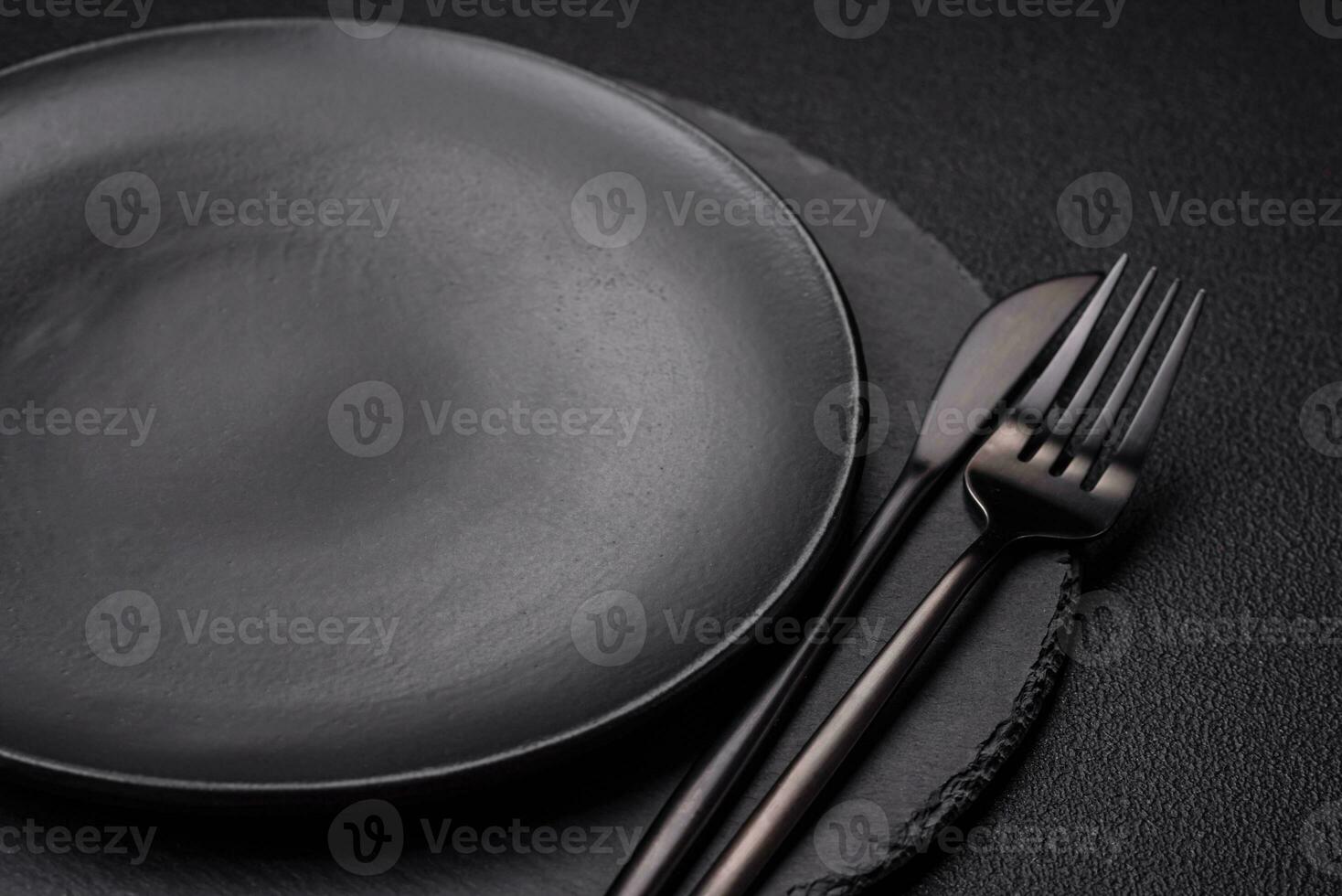 Empty black plate over dark stone background with copy space photo