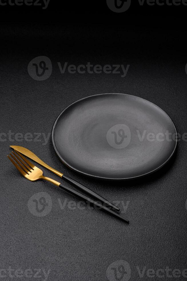 Empty black plate over dark stone background with copy space photo