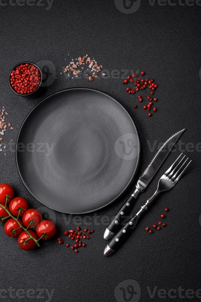 Empty black plate over dark stone background with copy space photo