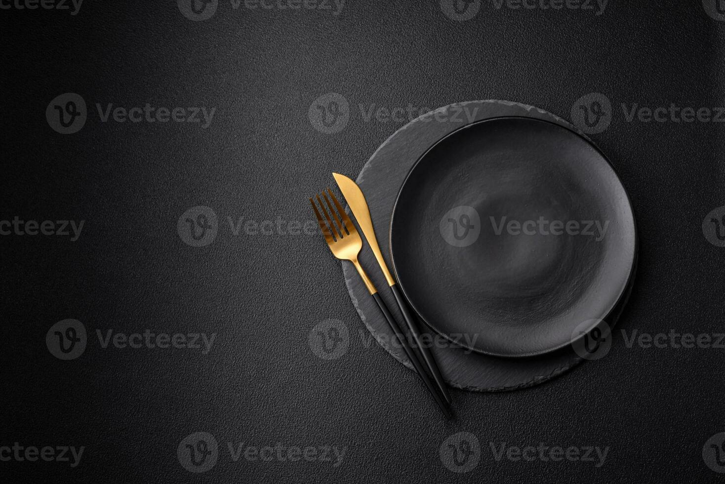 Empty black plate over dark stone background with copy space photo