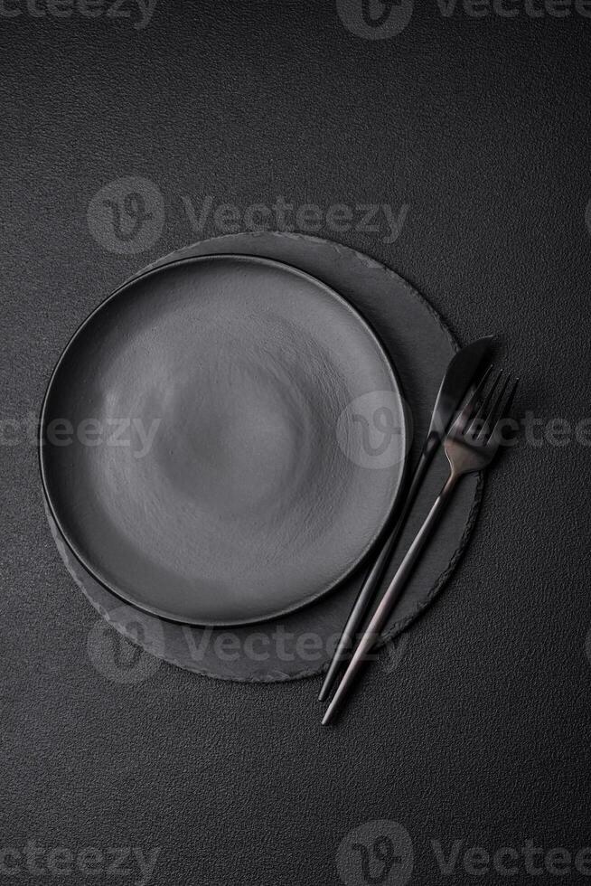Empty black plate over dark stone background with copy space photo