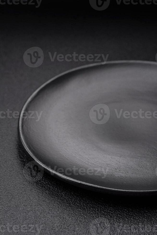 Empty black plate over dark stone background with copy space photo