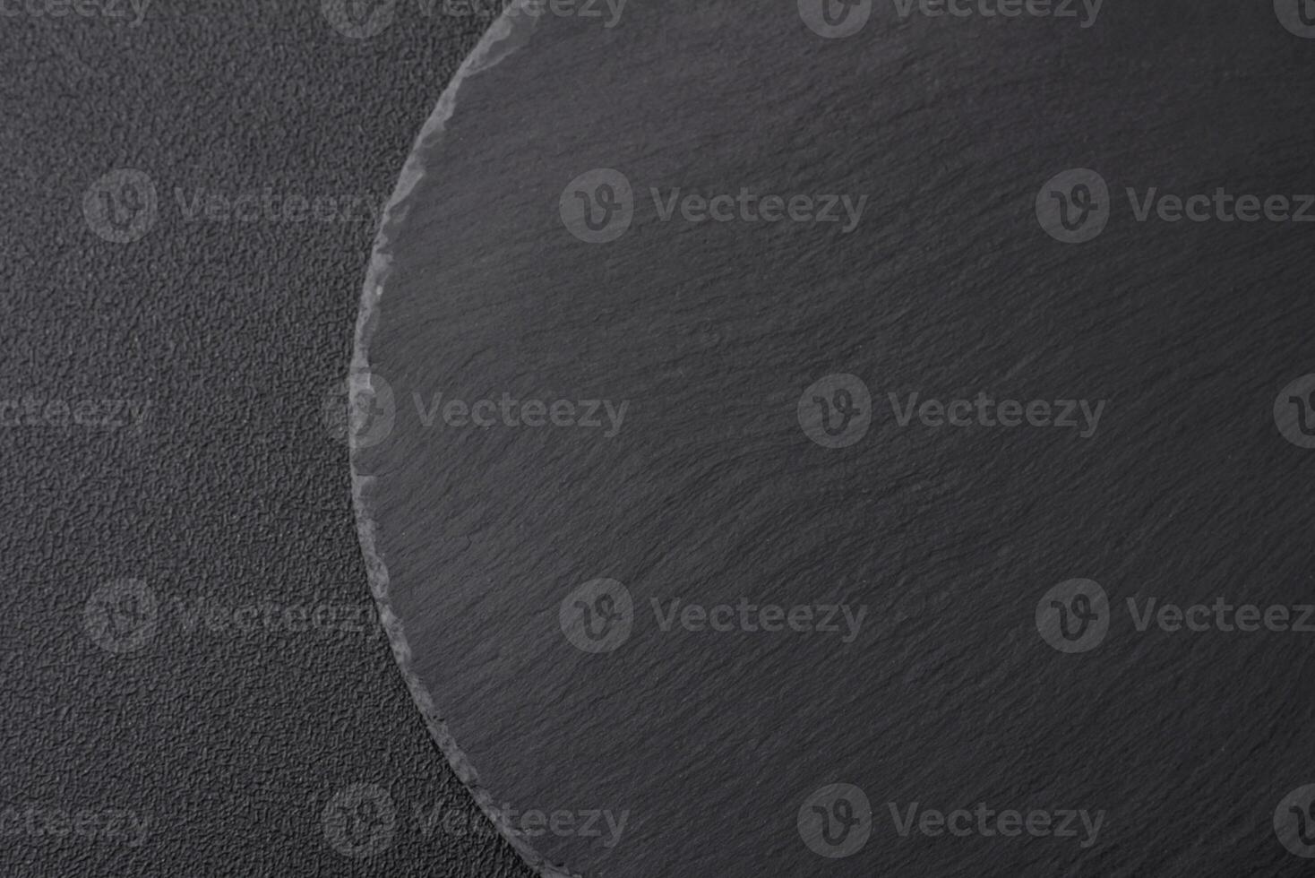 Empty black plate over dark stone background with copy space photo