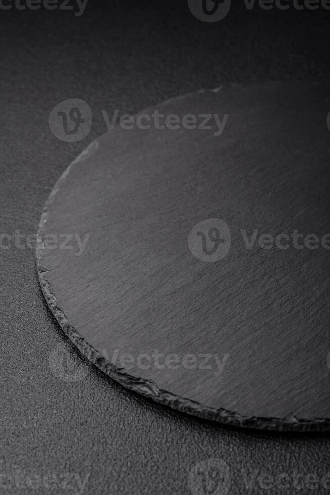 Empty black plate over dark stone background with copy space photo