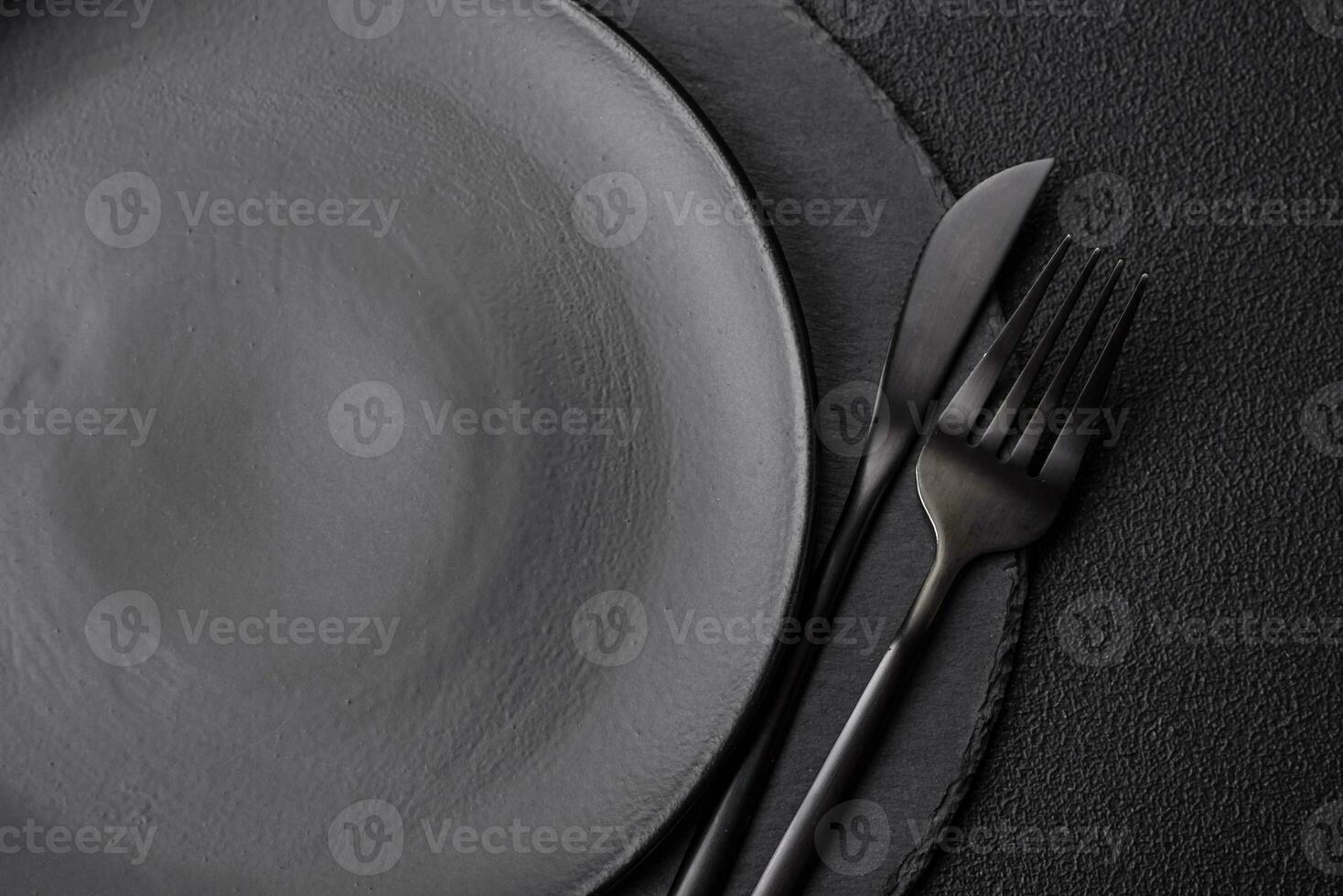 Empty black plate over dark stone background with copy space photo