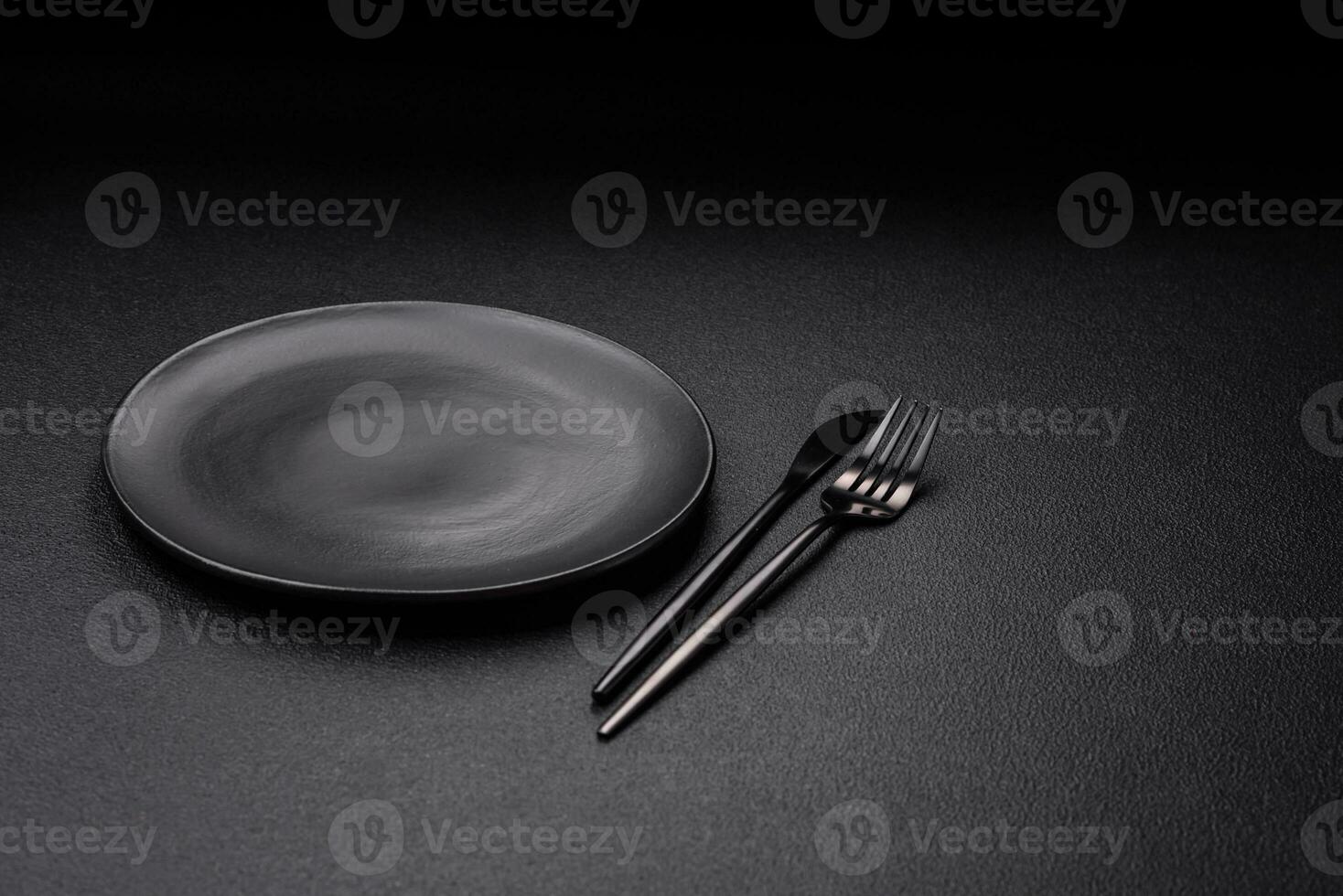 Empty black plate over dark stone background with copy space photo