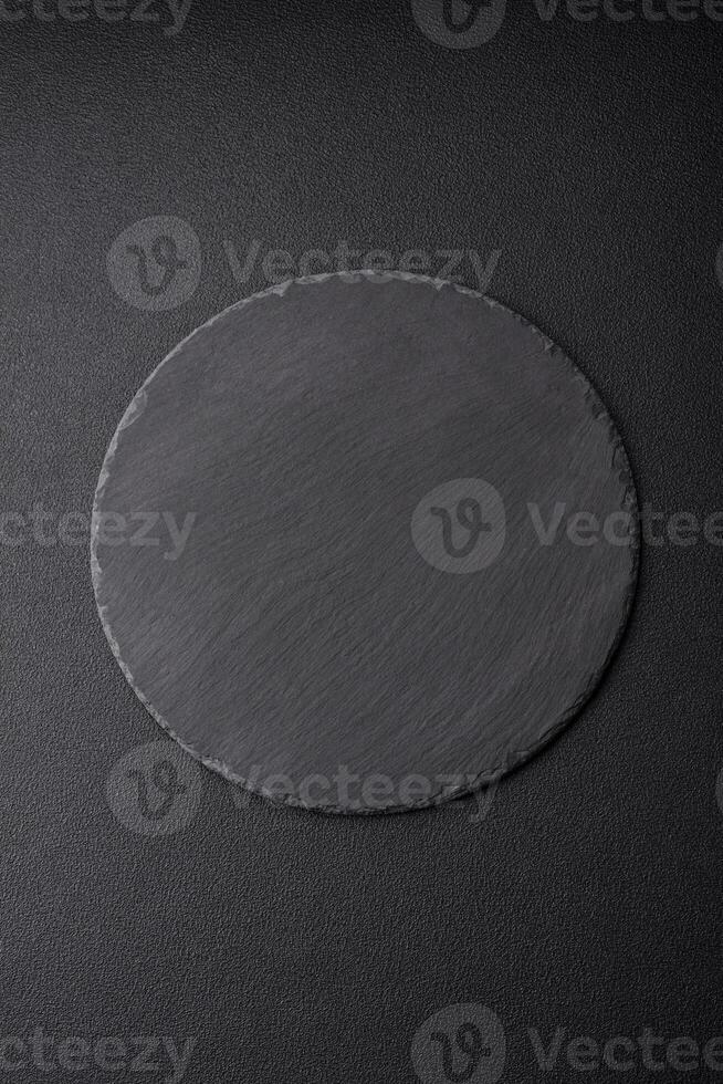 Empty black plate over dark stone background with copy space photo