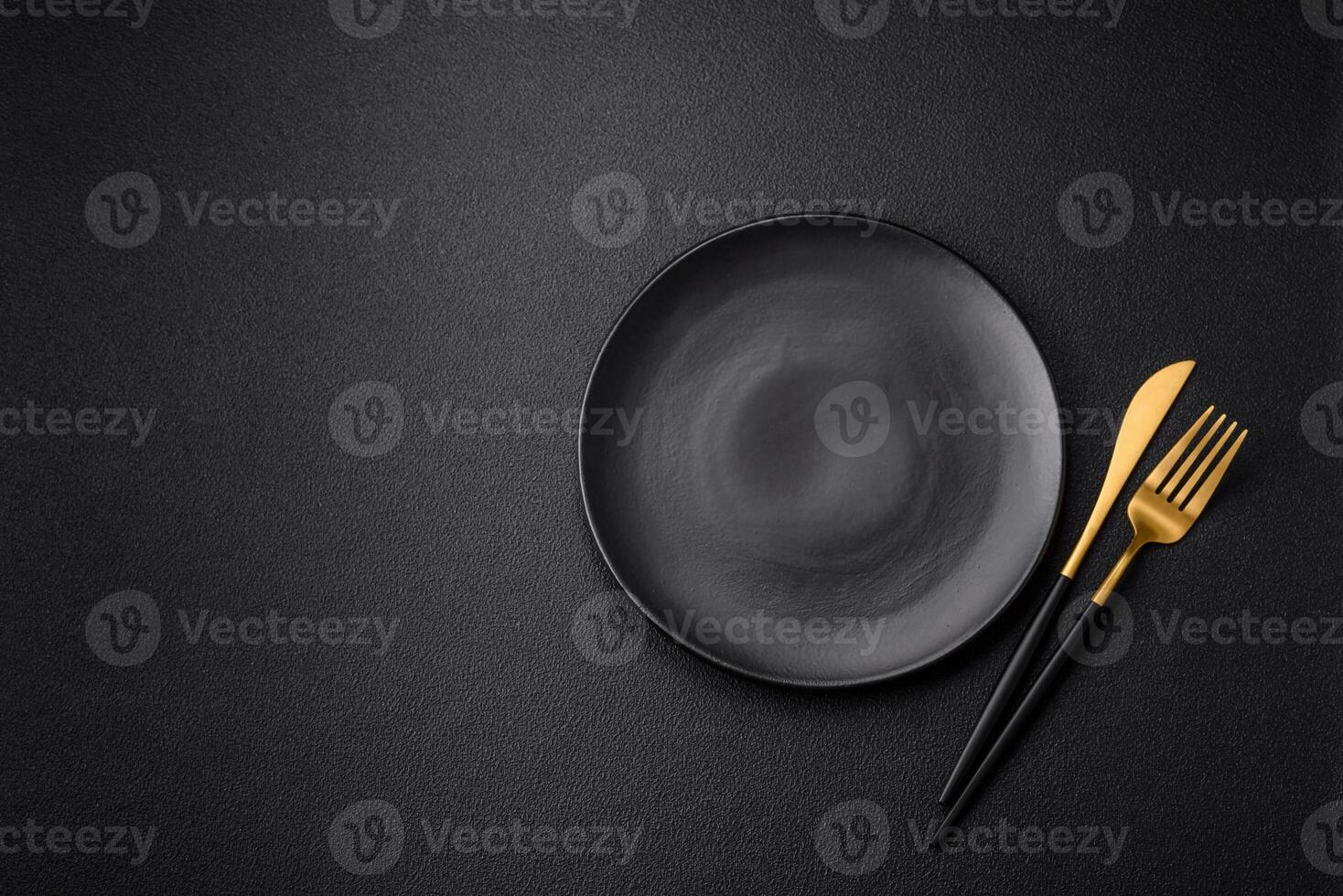 Empty black plate over dark stone background with copy space photo