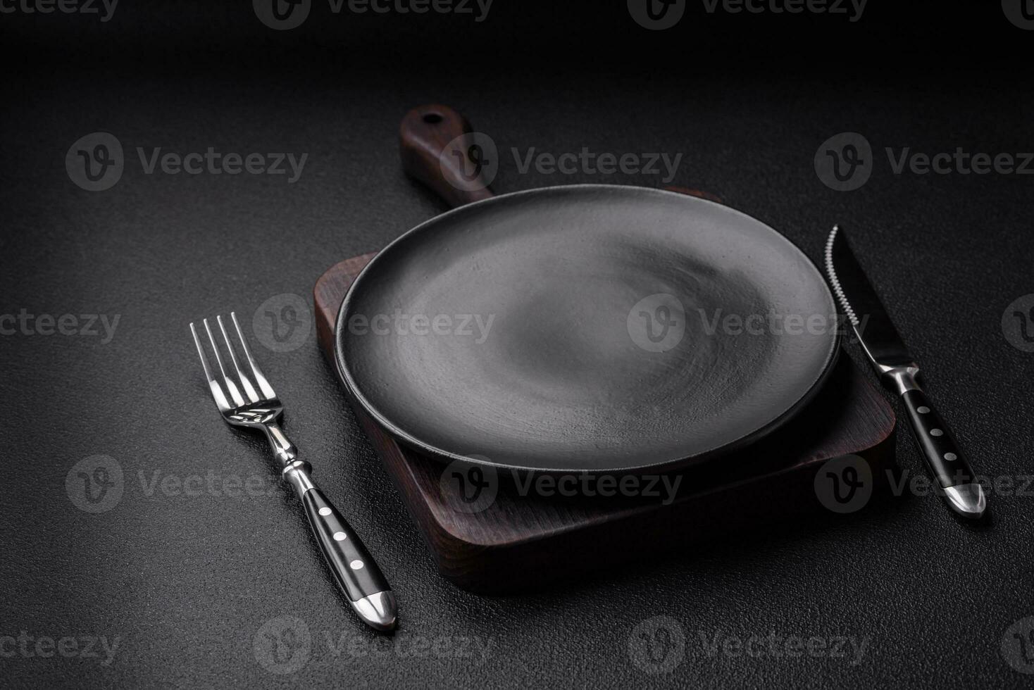 Empty black plate over dark stone background with copy space photo