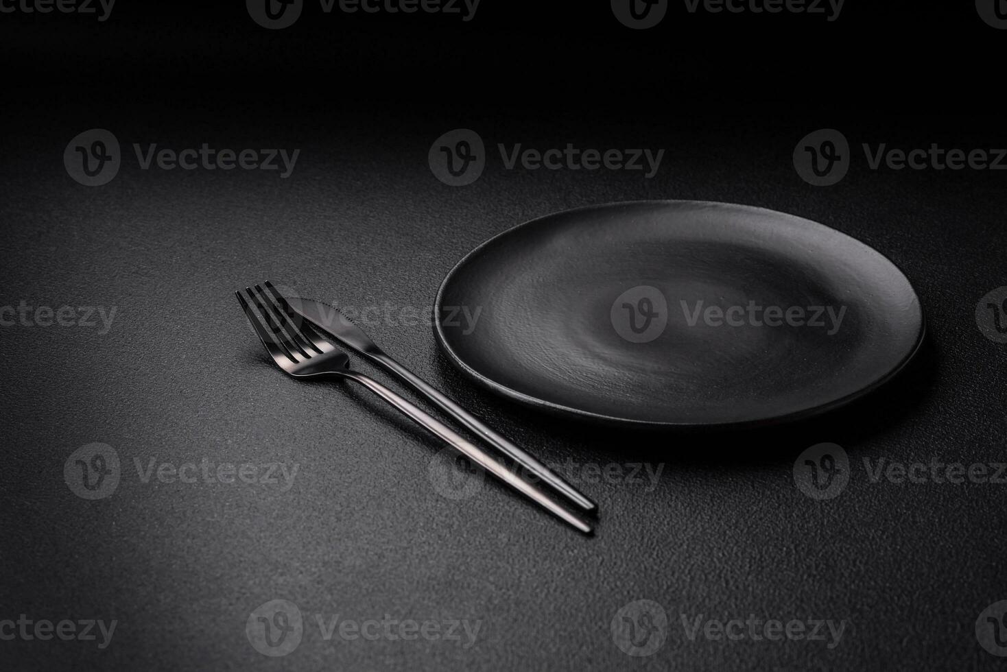 Empty black plate over dark stone background with copy space photo