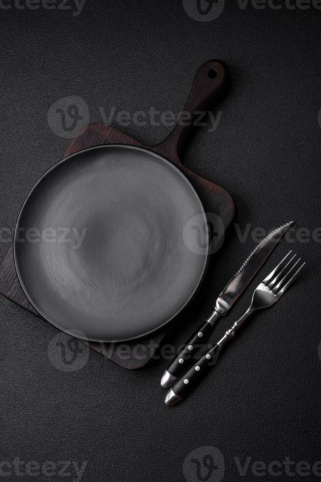Empty black plate over dark stone background with copy space photo