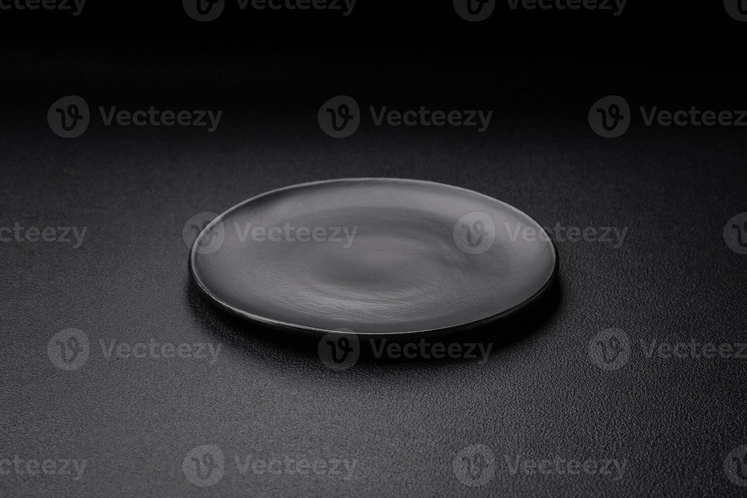 Empty black plate over dark stone background with copy space photo