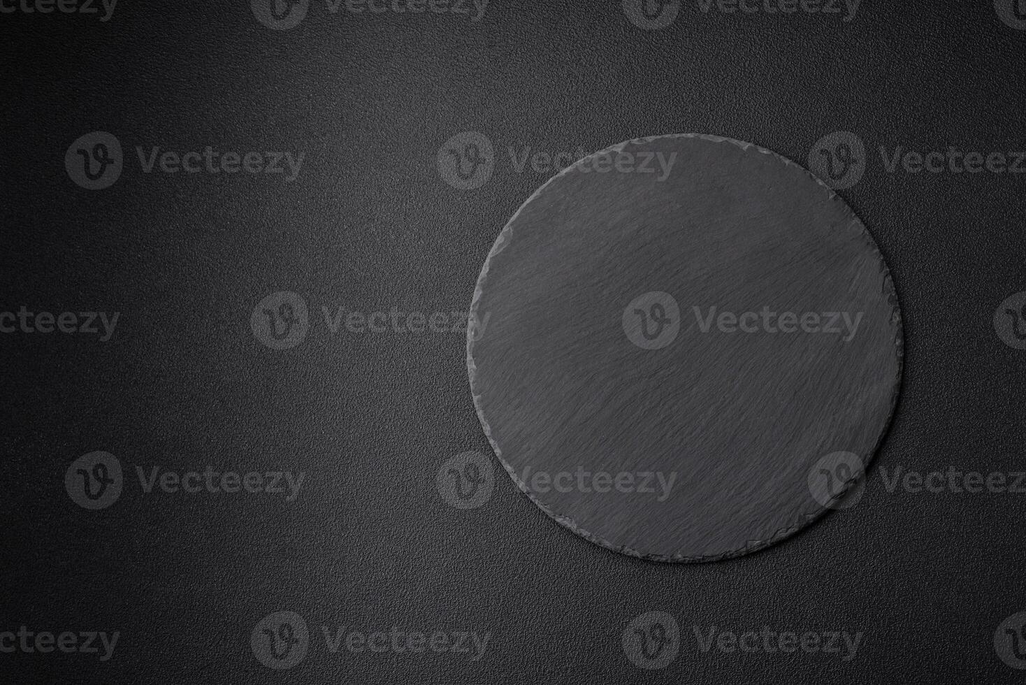 Empty black plate over dark stone background with copy space photo