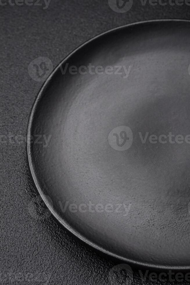 Empty black plate over dark stone background with copy space photo