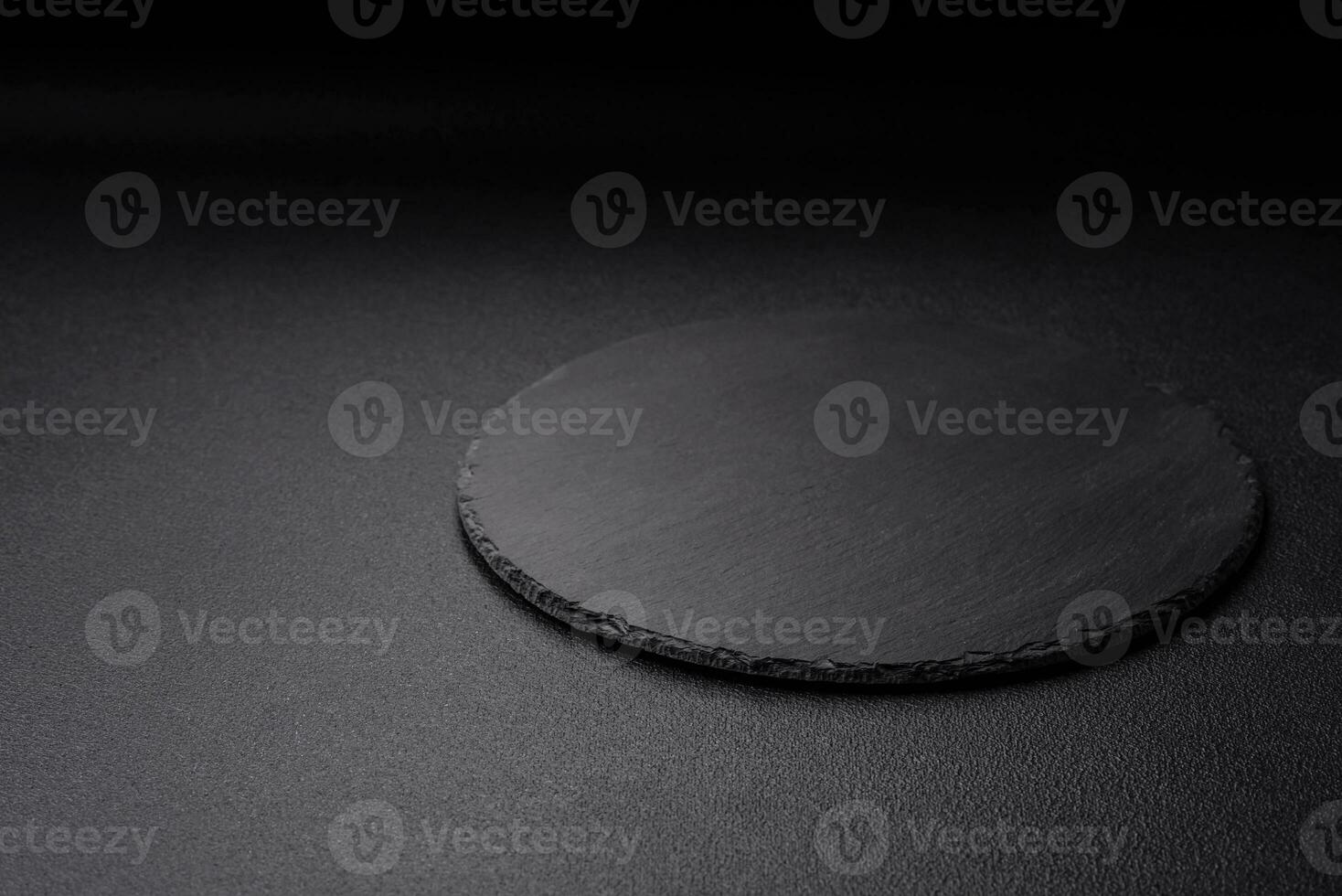 Empty black plate over dark stone background with copy space photo