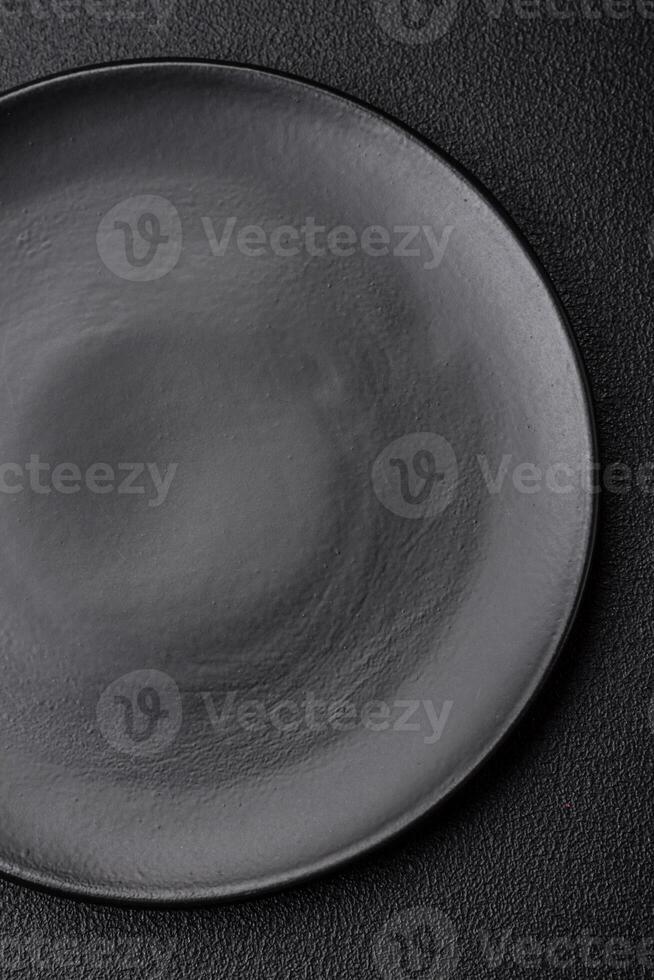 Empty black plate over dark stone background with copy space photo