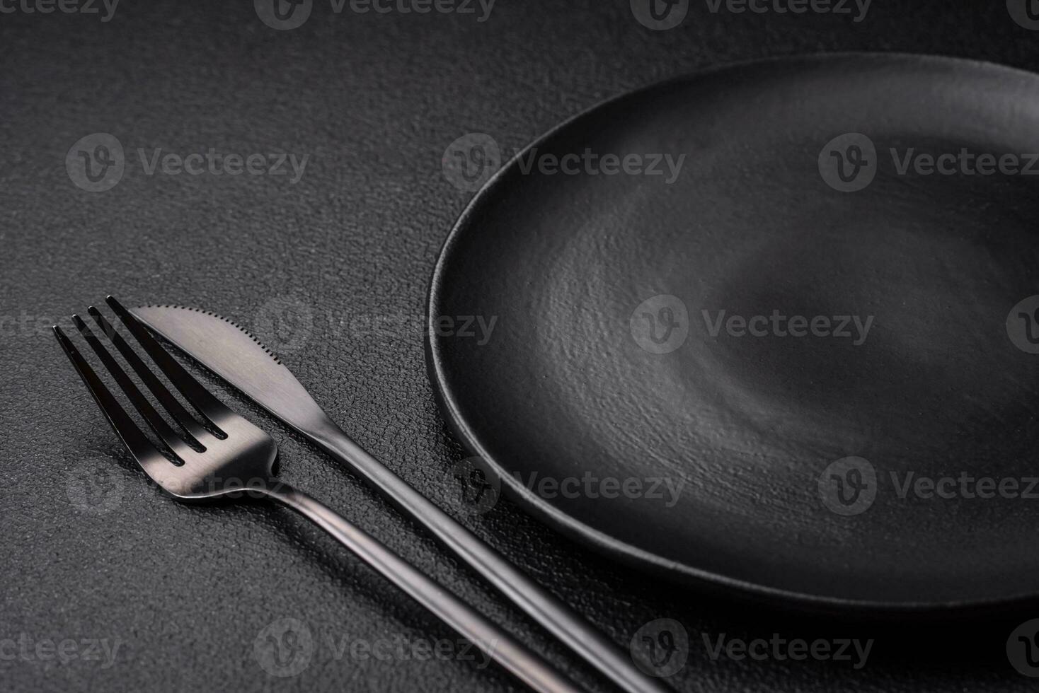 Empty black plate over dark stone background with copy space photo