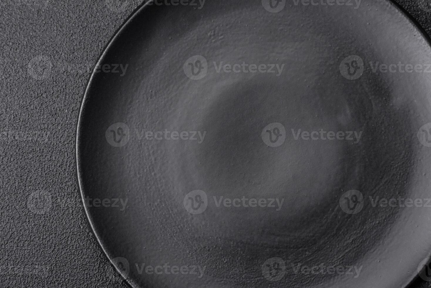 Empty black plate over dark stone background with copy space photo