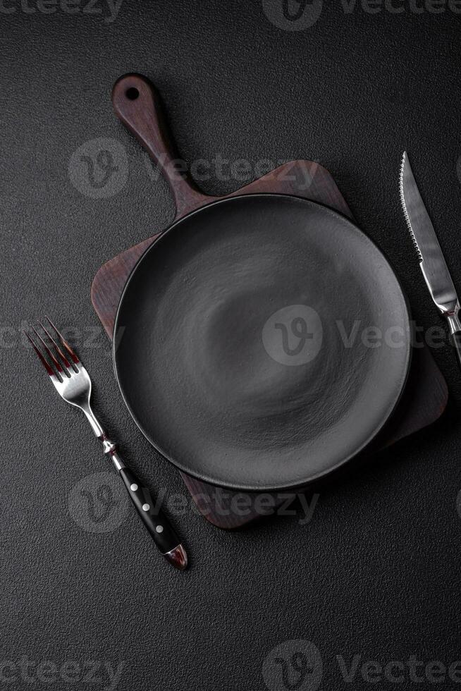 Empty black plate over dark stone background with copy space photo