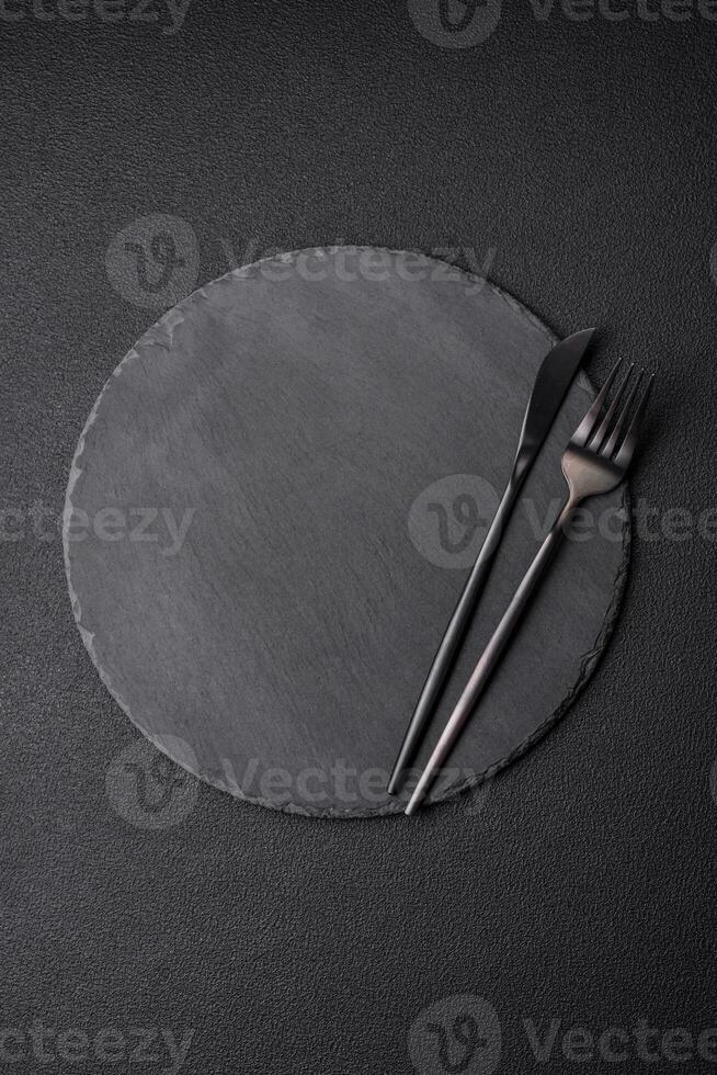Empty black plate over dark stone background with copy space photo