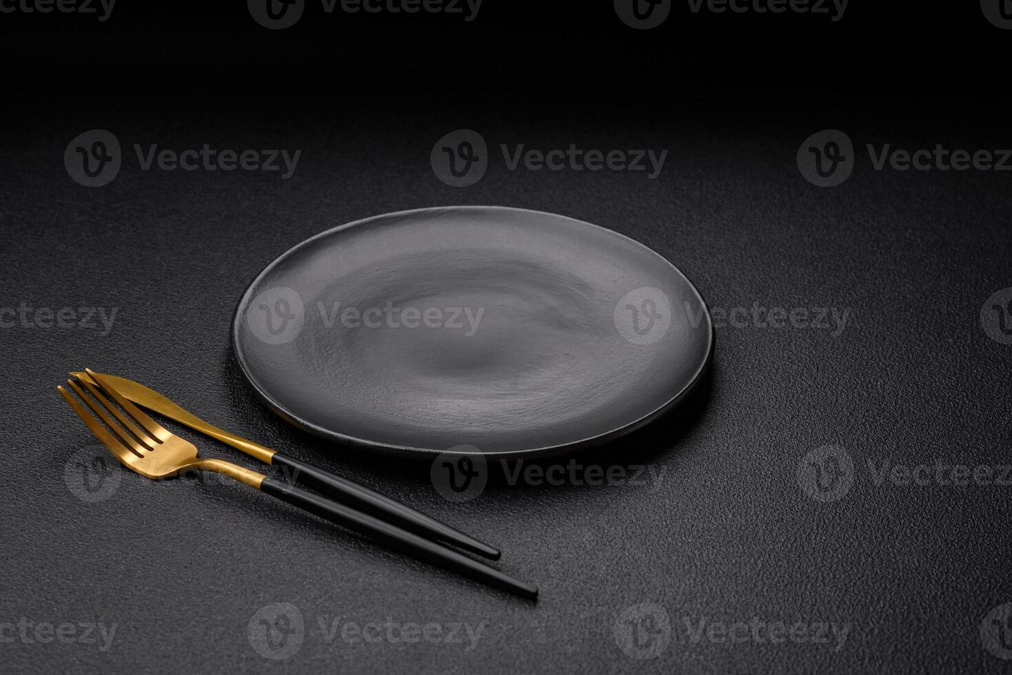 Empty black plate over dark stone background with copy space photo