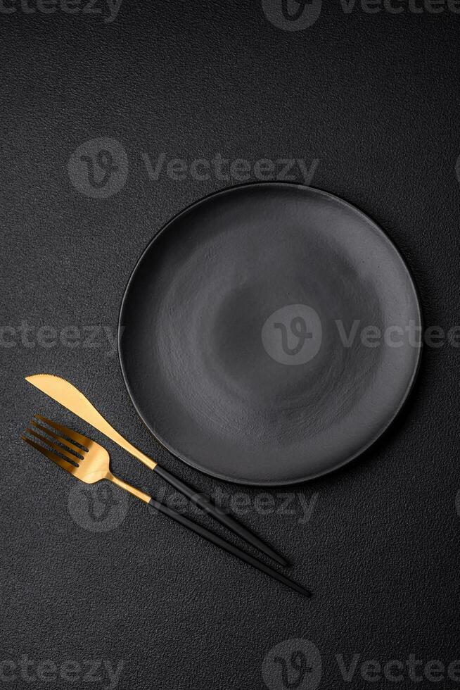 Empty black plate over dark stone background with copy space photo