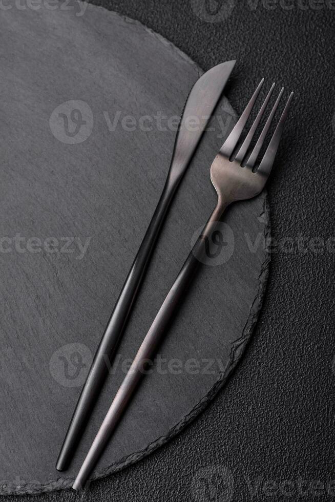 Empty black plate over dark stone background with copy space photo