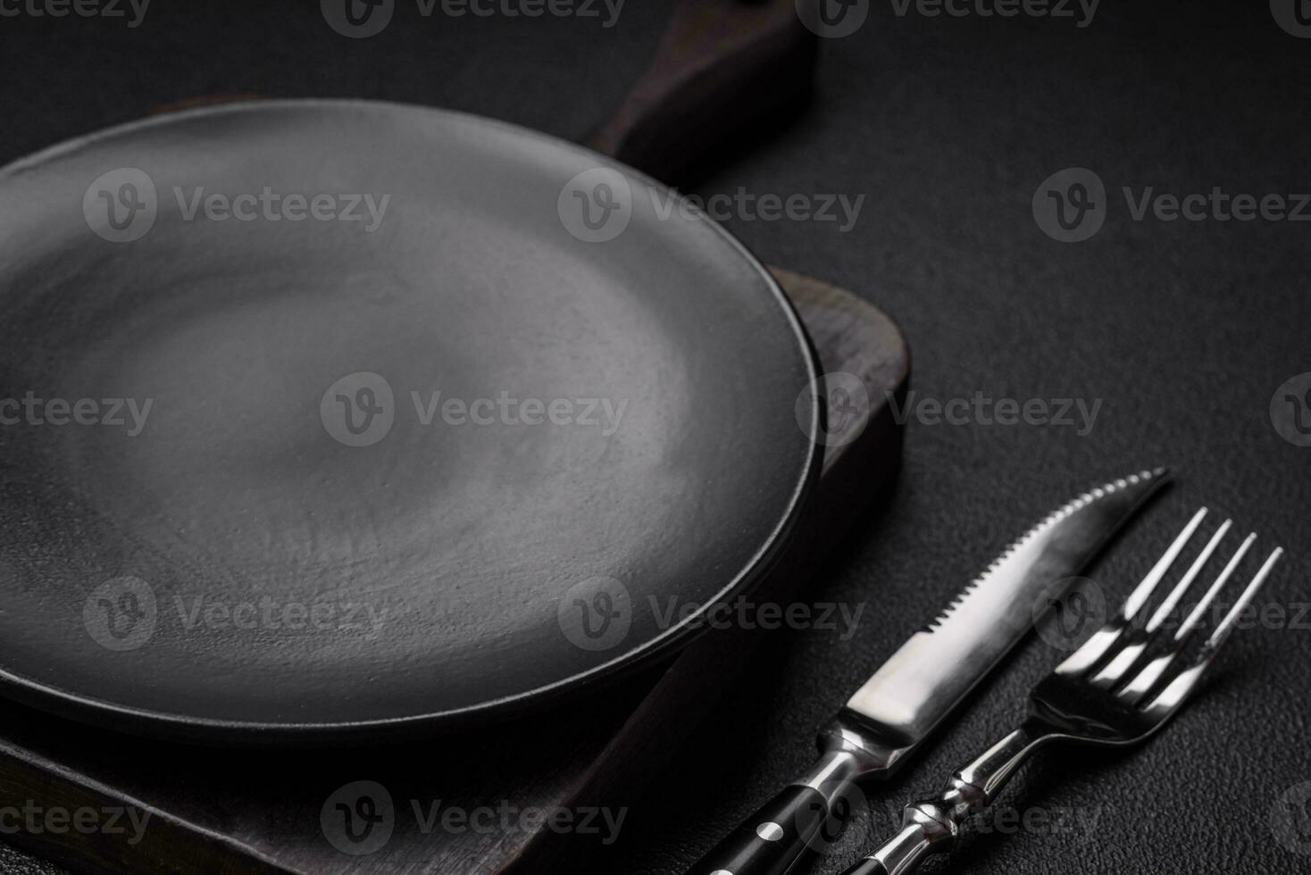 Empty black plate over dark stone background with copy space photo