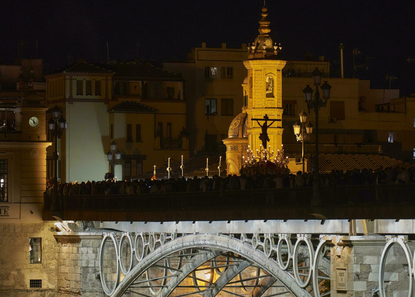 Christ the Pup.  Crossing Triana Bridge towards His Neighborhood, Amidst a Sea of Devotees and the Chapel of Carmen. Cristo el Cachorro, Puente de Triana. Sevilla photo